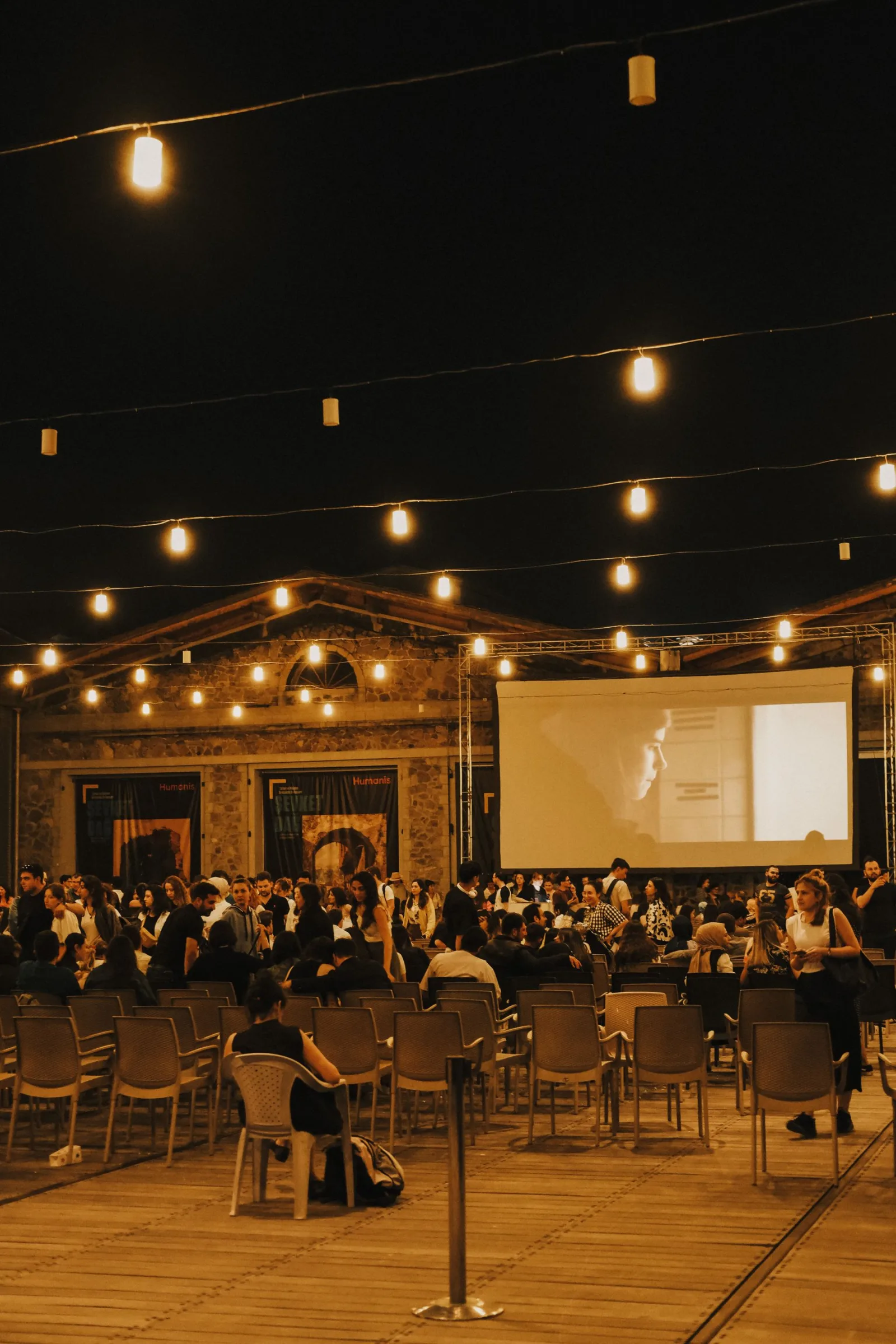 Peserta berkumpul dalam evening gathering dengan panggung dan lampu hangat