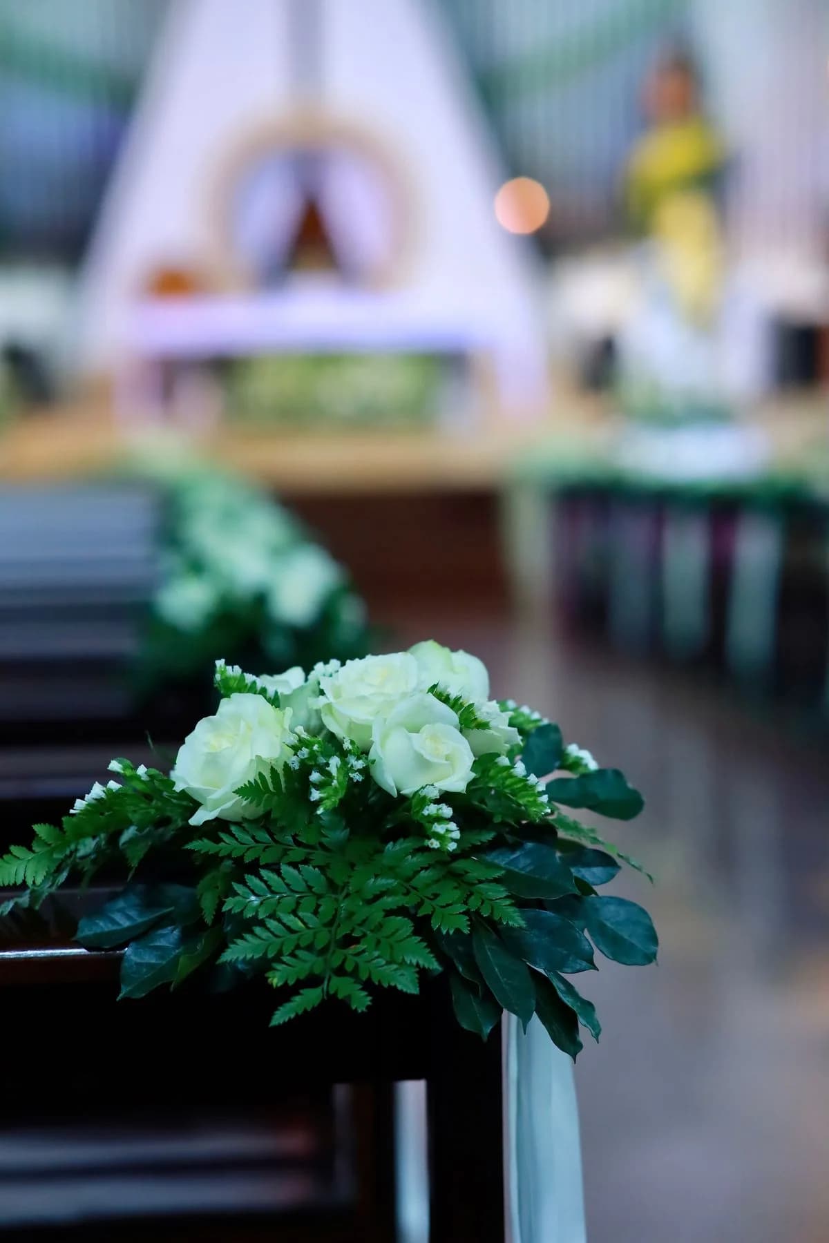 Wedding aisle dengan dekorasi bunga putih dan greenery