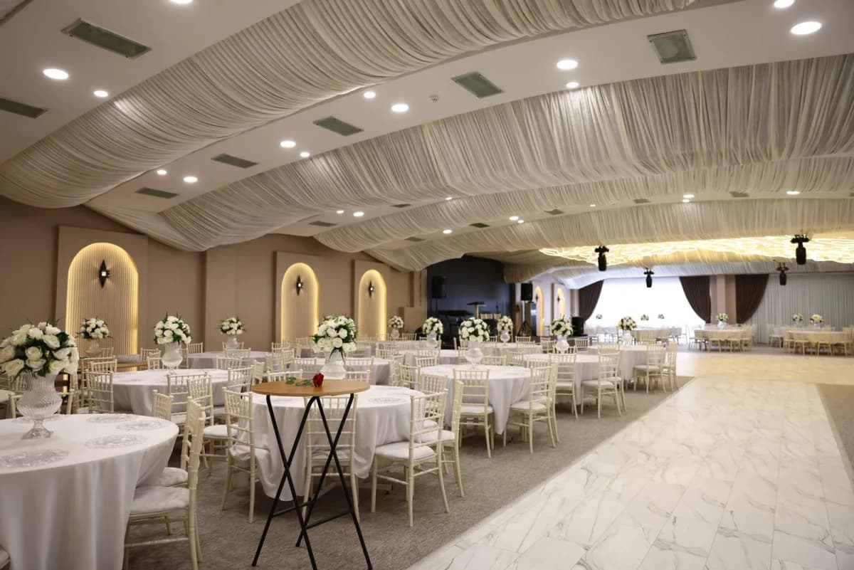Wedding reception di ballroom dengan tata meja elegan