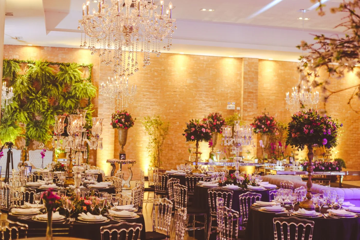 Suasana venue acara dengan table setting, chandelier, dan dekorasi floral hangat